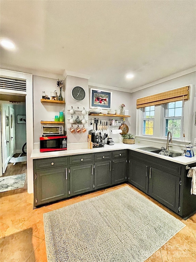 kitchen featuring open shelves, light countertops, ornamental molding, and a sink