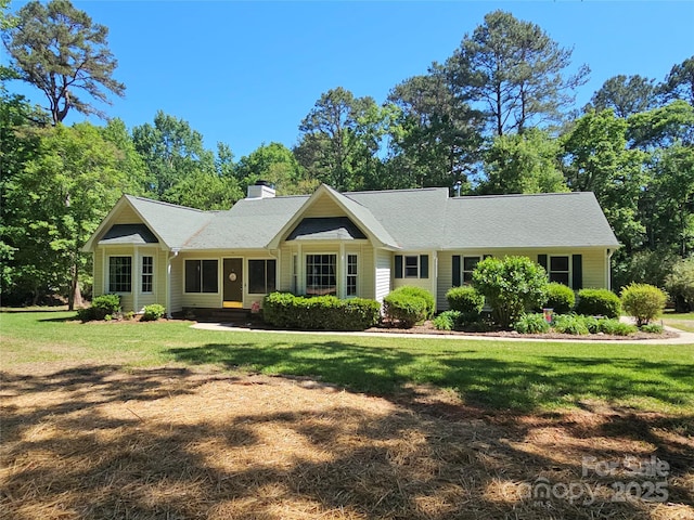 ranch-style house featuring a chimney and a front yard