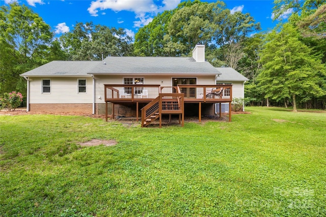 back of property with a wooden deck, a chimney, a yard, and stairway
