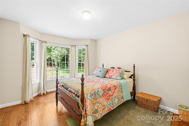 bedroom featuring baseboards and light wood finished floors