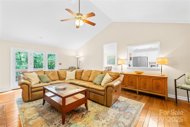 living room with light wood finished floors, ceiling fan, and vaulted ceiling