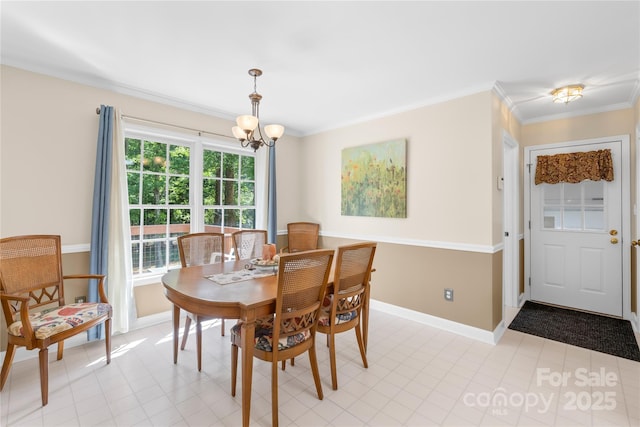 dining space featuring a chandelier, baseboards, and crown molding