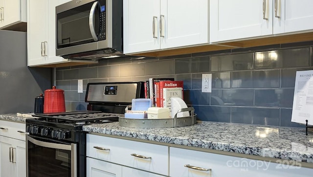 kitchen with white cabinets, appliances with stainless steel finishes, decorative backsplash, and light stone counters