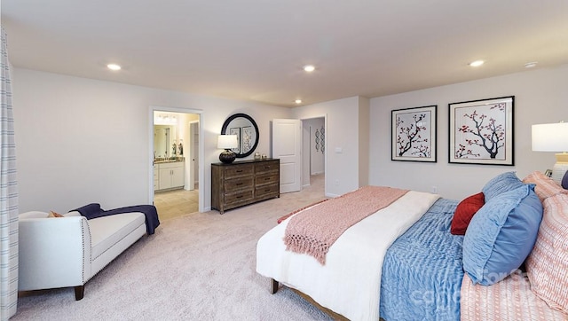 bedroom featuring light colored carpet, recessed lighting, and ensuite bath