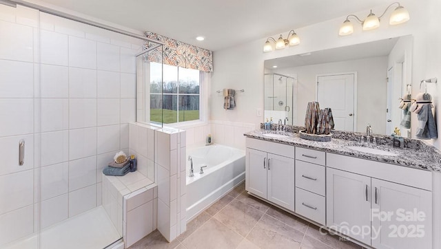 bathroom featuring a sink, double vanity, a stall shower, and a bath