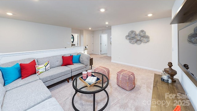 living area featuring baseboards, light carpet, attic access, and recessed lighting