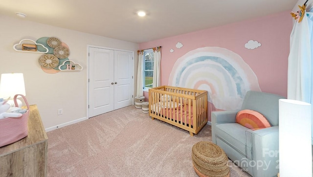 carpeted bedroom with a closet and baseboards