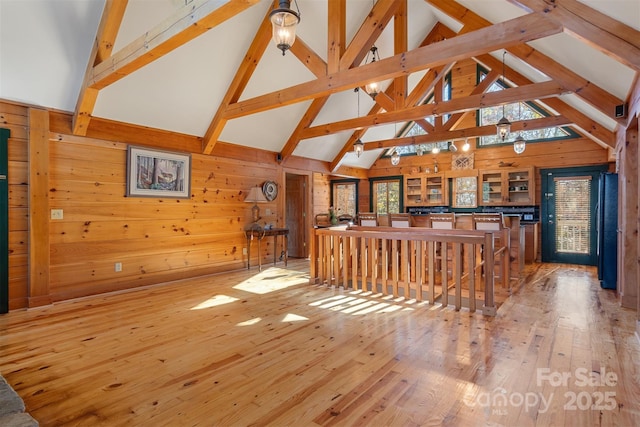 969 Twin Bridges Dr, Fleetwood, NC 28626 - living area featuring wooden walls, beamed ceiling, high vaulted ceiling, and light wood-style floors
