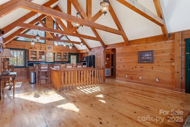 969 Twin Bridges Dr, Fleetwood, NC 28626 - living room with visible vents, wooden walls, high vaulted ceiling, light wood-style floors, and beam ceiling