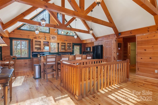 969 Twin Bridges Dr, Fleetwood, NC 28626 - kitchen with wooden walls, black refrigerator with ice dispenser, and stainless steel microwave
