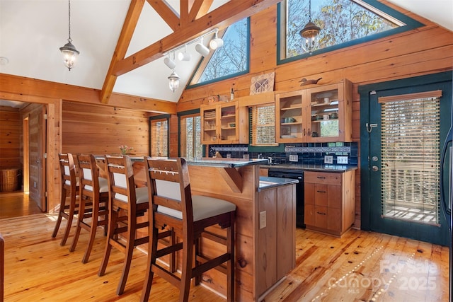969 Twin Bridges Dr, Fleetwood, NC 28626 - bar with high vaulted ceiling, black dishwasher, light wood-type flooring, beamed ceiling, and wooden walls