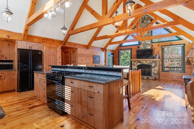 969 Twin Bridges Dr, Fleetwood, NC 28626 - kitchen featuring dark countertops, wooden walls, light wood-style flooring, and black appliances