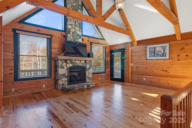 969 Twin Bridges Dr, Fleetwood, NC 28626 - living area featuring wood walls, a fireplace, beam ceiling, and wood finished floors