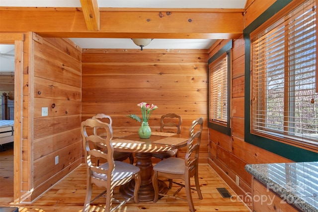 969 Twin Bridges Dr, Fleetwood, NC 28626 - dining space with light wood-style floors, wood walls, and visible vents
