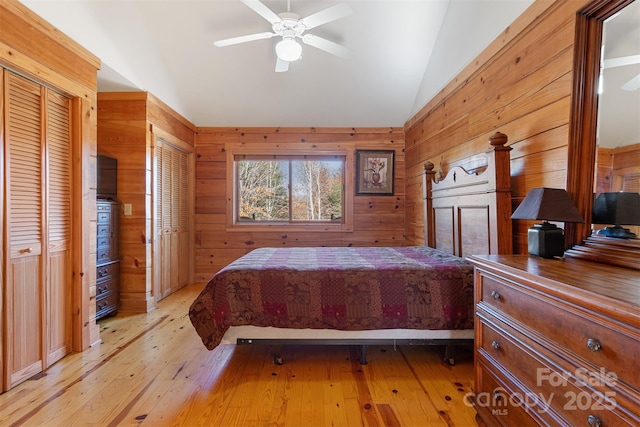 969 Twin Bridges Dr, Fleetwood, NC 28626 - bedroom featuring light wood finished floors, wood walls, lofted ceiling, and multiple closets