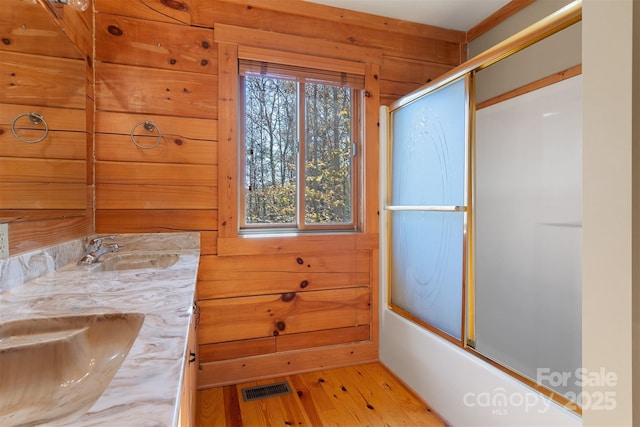 969 Twin Bridges Dr, Fleetwood, NC 28626 - full bath featuring enclosed tub / shower combo, visible vents, a sink, double vanity, and wood finished floors