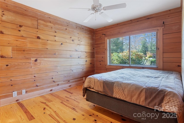 969 Twin Bridges Dr, Fleetwood, NC 28626 - bedroom with a ceiling fan, wooden walls, and wood finished floors