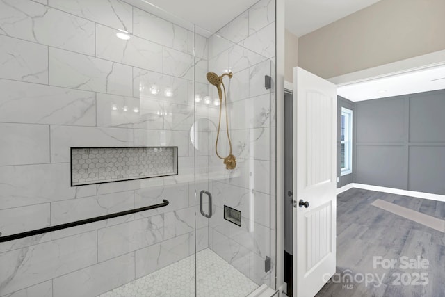 bathroom with wood finished floors and a stall shower