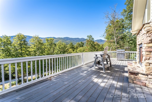 wooden deck with area for grilling and a mountain view