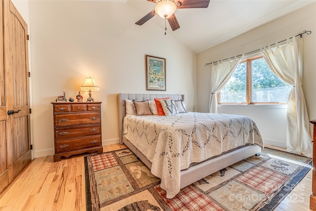 bedroom featuring lofted ceiling, baseboards, light wood finished floors, and a ceiling fan