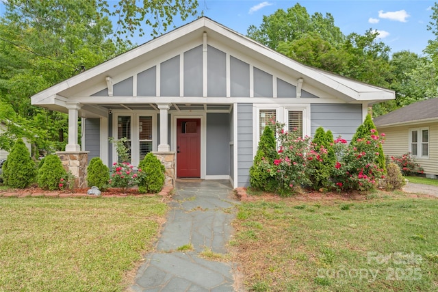 view of front facade featuring covered porch and a front yard