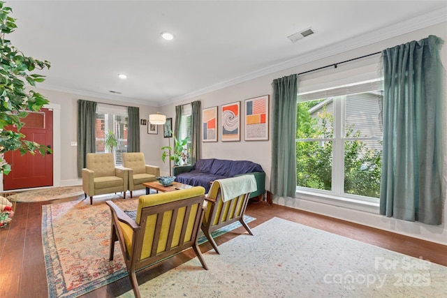 living area with crown molding, recessed lighting, wood finished floors, and visible vents