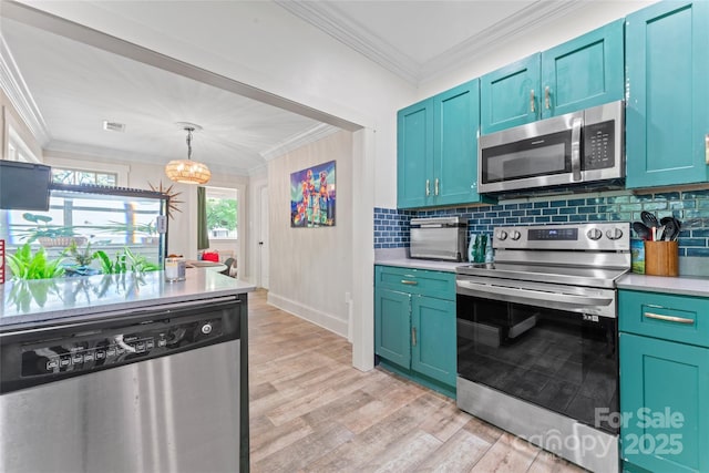 kitchen with light wood-style floors, light countertops, ornamental molding, and stainless steel appliances