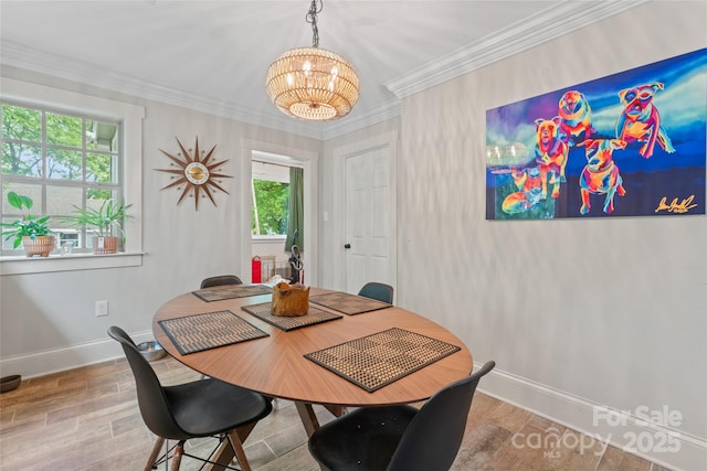 dining room with baseboards, an inviting chandelier, ornamental molding, and wood finished floors
