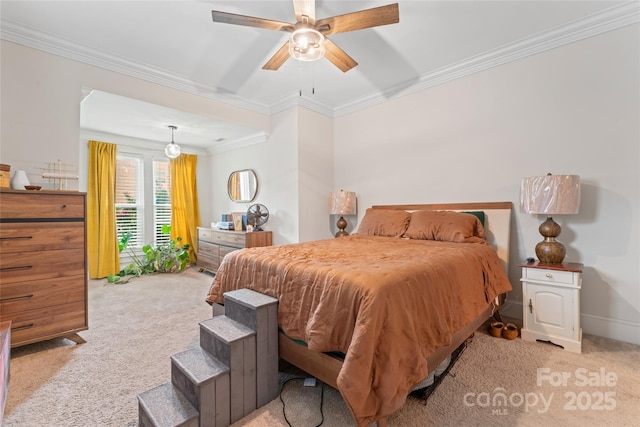 carpeted bedroom featuring crown molding, a ceiling fan, and baseboards