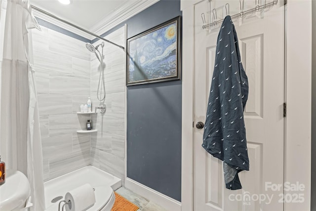 bathroom with crown molding, baseboards, toilet, and tiled shower