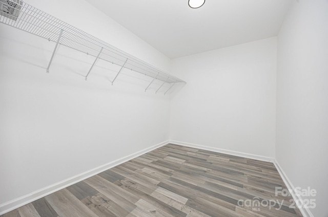 walk in closet with wood finished floors