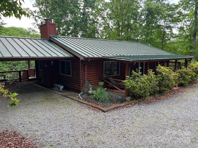 137 Amys Ridge Rd, Lake Lure, NC 28746 - view of front of property featuring an attached carport, a chimney, a standing seam roof, driveway, and metal roof
