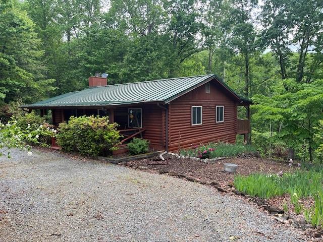 137 Amys Ridge Rd, Lake Lure, NC 28746 - view of property exterior with a standing seam roof, driveway, a chimney, and metal roof