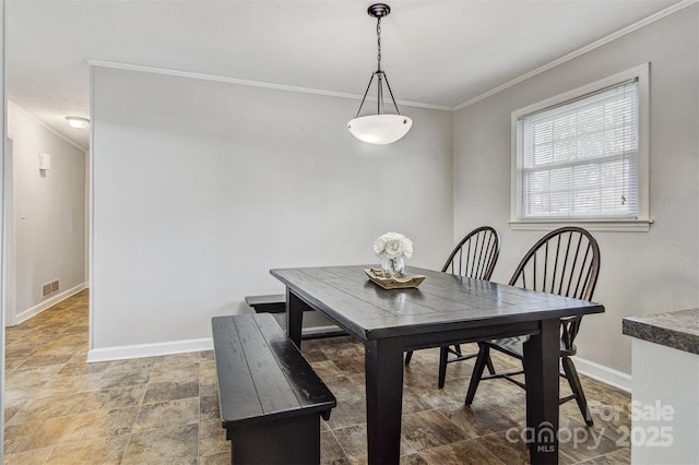 dining room with crown molding, stone finish flooring, baseboards, and visible vents
