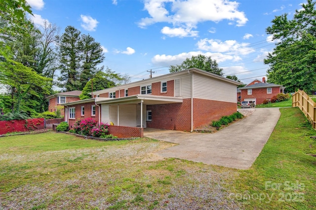 view of front of property with brick siding, driveway, and a front lawn