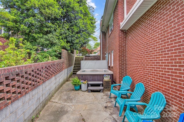 view of patio / terrace featuring fence and a hot tub
