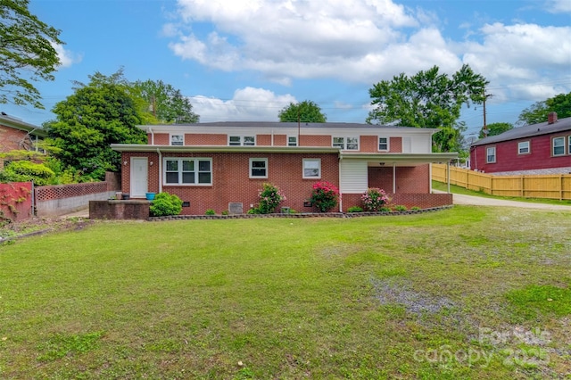 ranch-style home featuring brick siding, fence, and a front yard