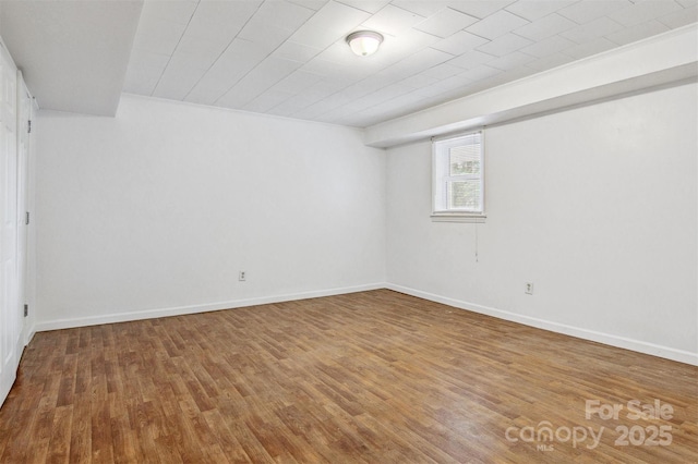 basement featuring baseboards and wood finished floors