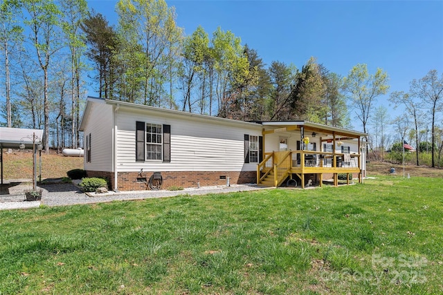 manufactured / mobile home featuring a deck, a front yard, and crawl space