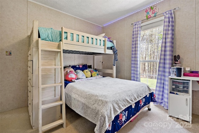 carpeted bedroom with ornamental molding and a textured ceiling
