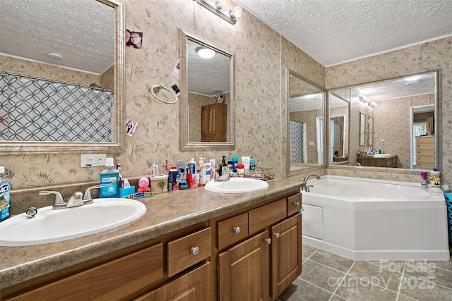 bathroom featuring a textured ceiling, tile patterned floors, wallpapered walls, a garden tub, and double vanity