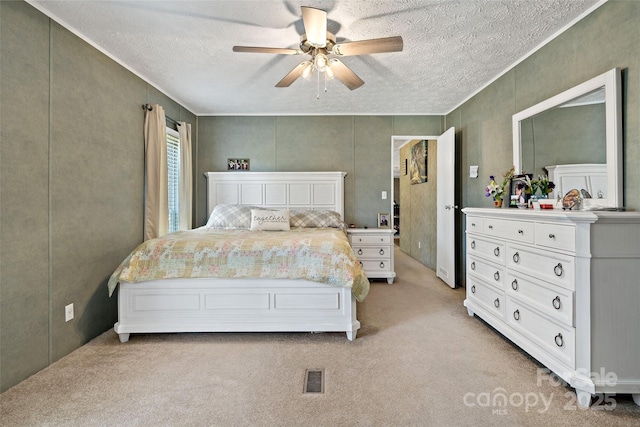 bedroom featuring a textured ceiling, light carpet, and ceiling fan