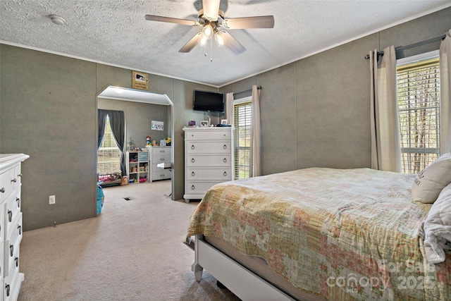 bedroom featuring carpet floors, a textured ceiling, arched walkways, and ceiling fan