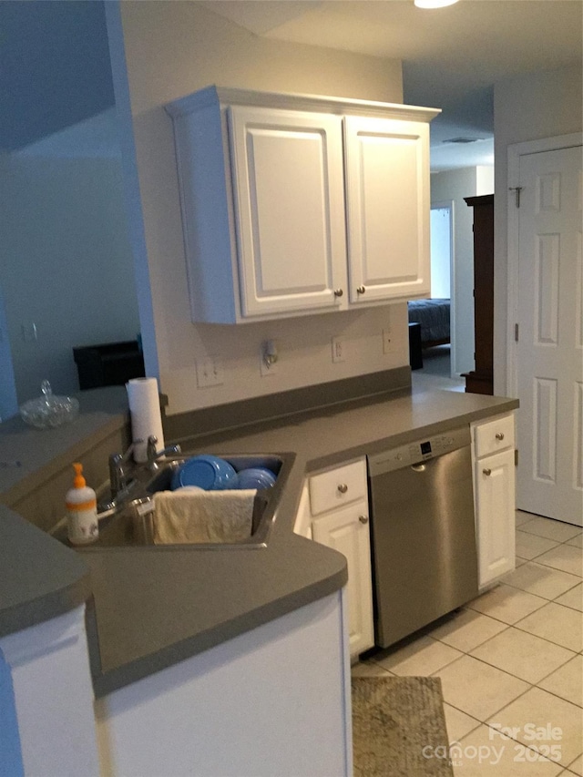 kitchen featuring a peninsula, white cabinetry, light tile patterned floors, and dishwasher