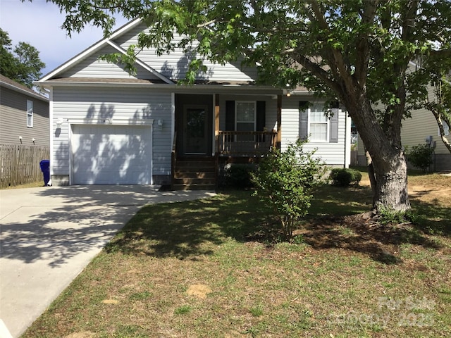 236 35th St NE, Oak Island, NC 28465 - view of front of home with a porch, fence, driveway, a garage, and a front lawn
