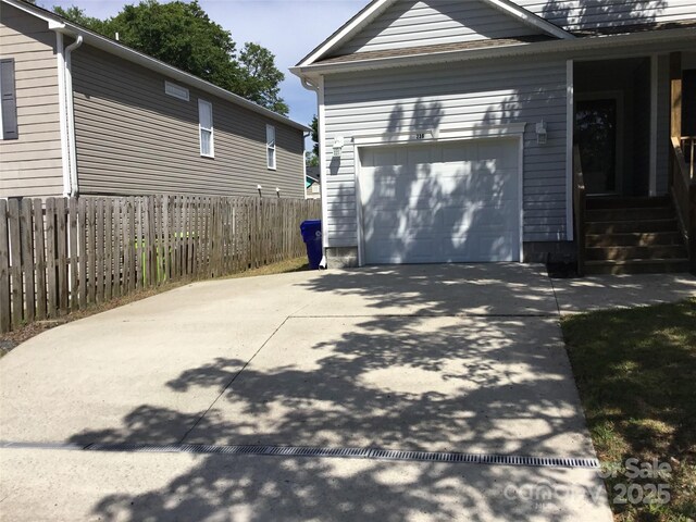 236 35th St NE, Oak Island, NC 28465 - view of property exterior featuring fence, a garage, and driveway