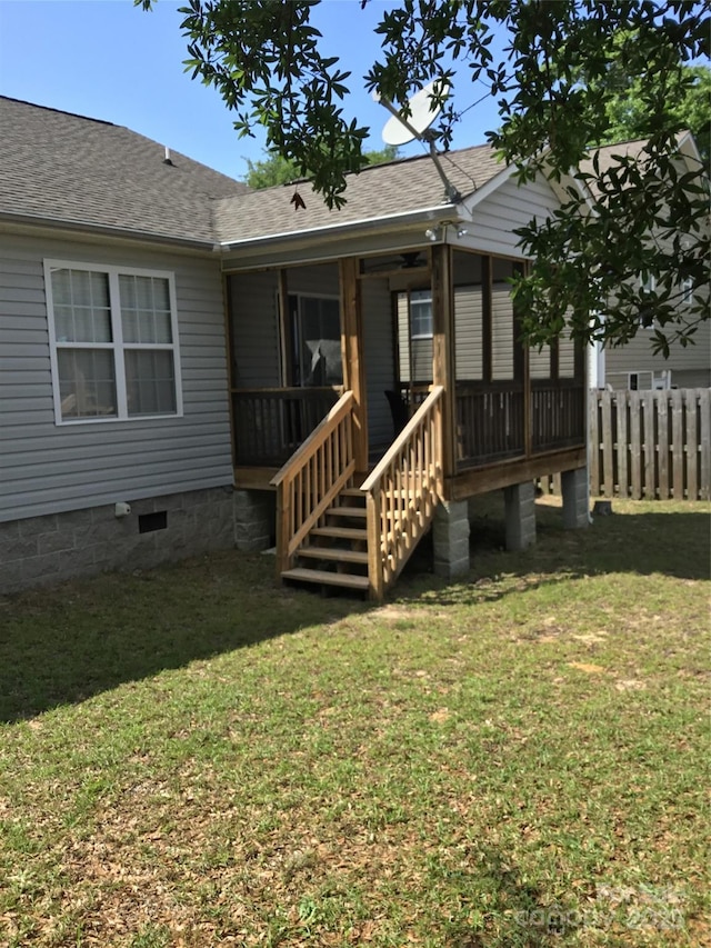 236 35th St NE, Oak Island, NC 28465 - rear view of property with fence, a shingled roof, and a lawn