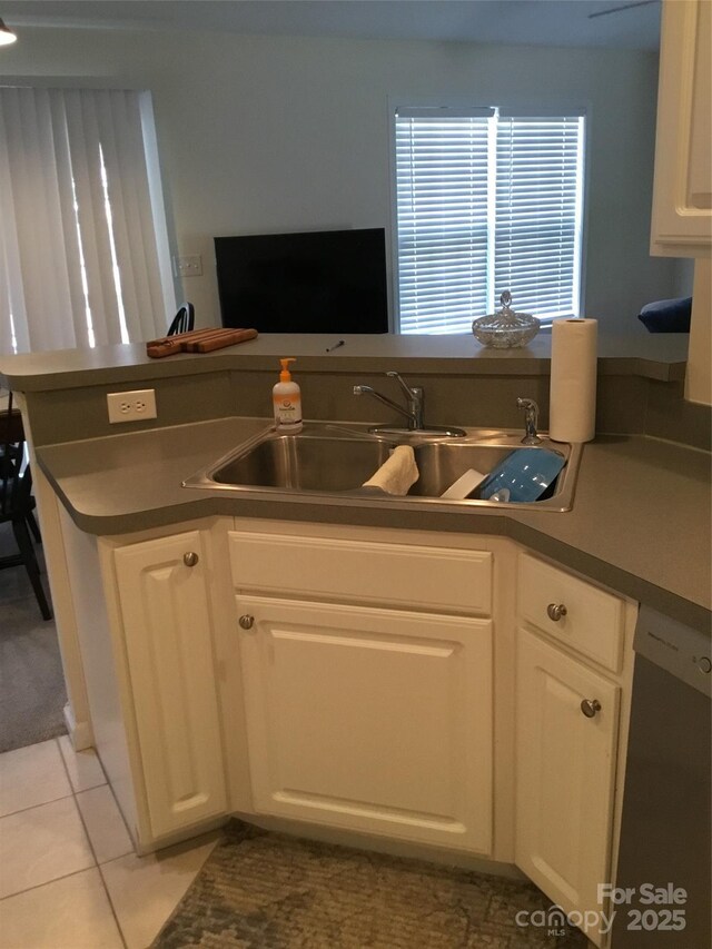 236 35th St NE, Oak Island, NC 28465 - kitchen featuring a sink, tile patterned flooring, dishwashing machine, and white cabinets