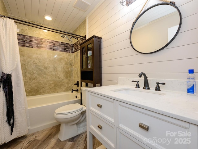 bathroom with visible vents, wood finished floors, vanity, toilet, and shower / tub combo with curtain