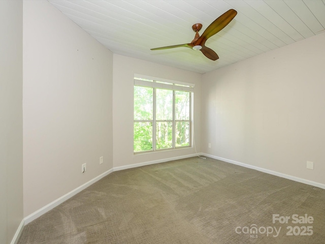 carpeted empty room featuring baseboards and ceiling fan
